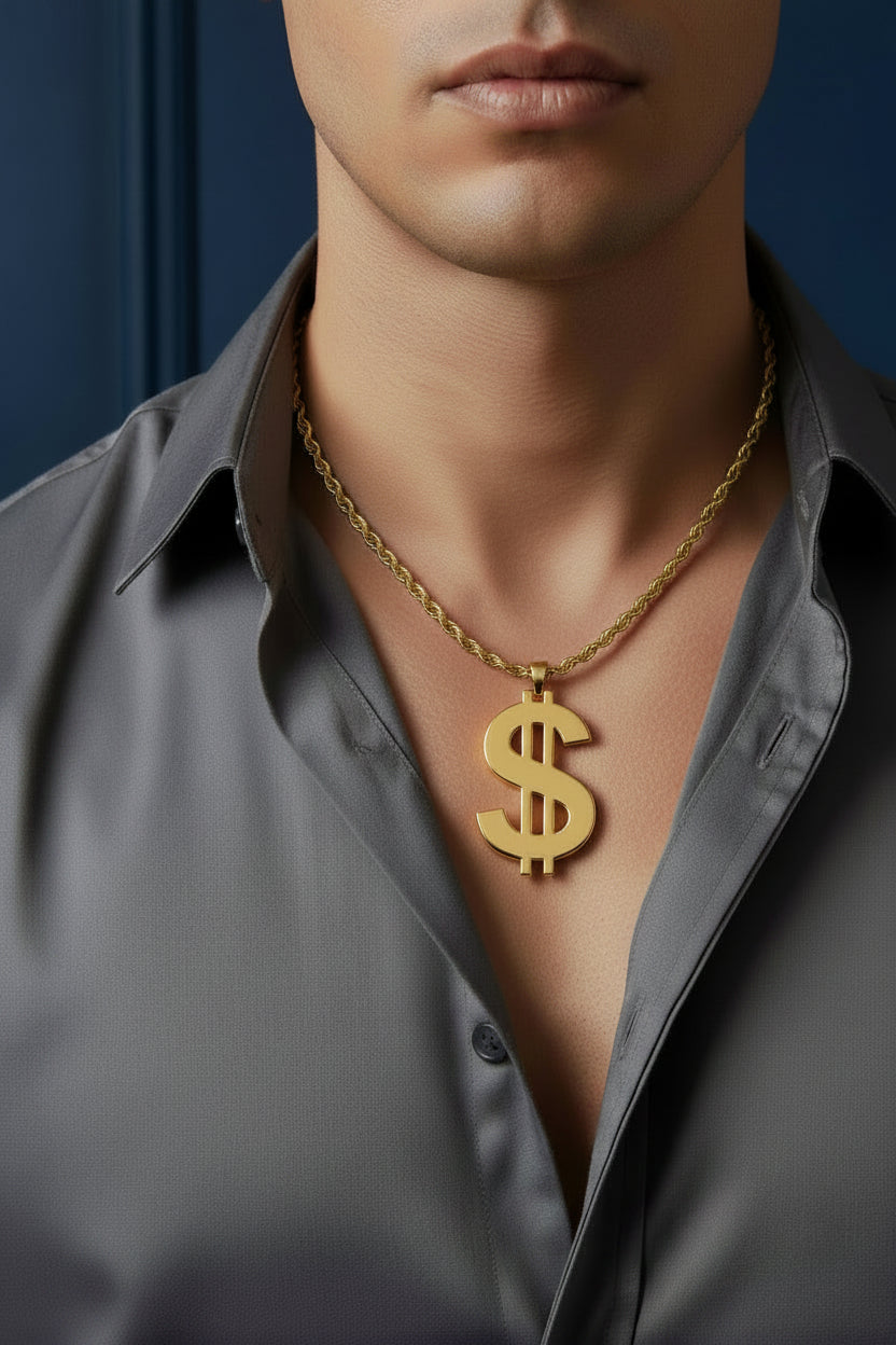 A gold-colored chain necklace with a dollar sign pendant, laid flat on a dark textured fabric background.