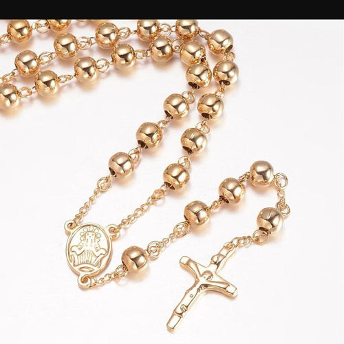 A gold rosary necklace with polished round beads, a medallion, and a crucifix, displayed on a plain white background.