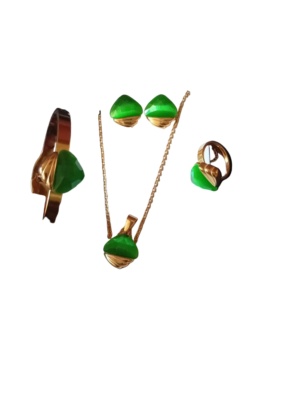 A gold-toned jewelry set with green stones, including a necklace, earrings, and a bracelet, displayed on a white card with a hand holding the bracelet at the bottom against a black textured background.