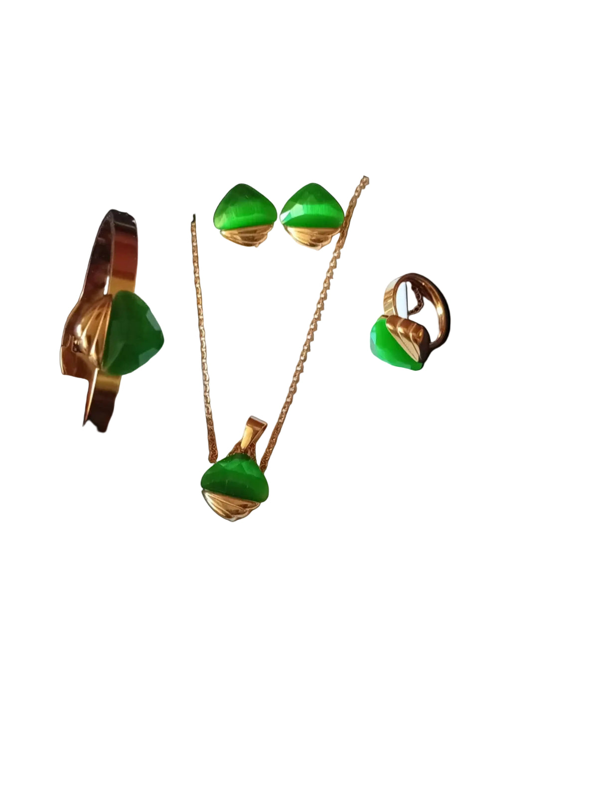 A gold-toned jewelry set with green stones, including a necklace, earrings, and a bracelet, displayed on a white card with a hand holding the bracelet at the bottom against a black textured background.